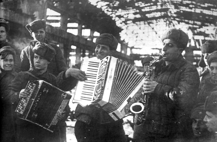 Красноармейцы играют на музыкальных инструментах в разрушенном цехе в Сталинграде